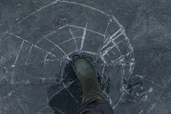 A person walks on cracking ice, symbolising precarity