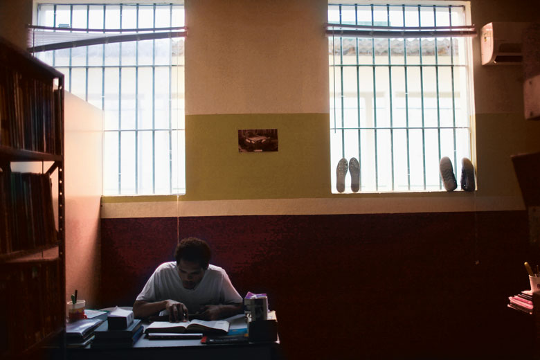 prisoner at desk with book