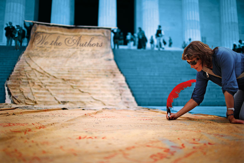 A woman signs a giant banner to illustrate Editors have become so wayward that authors need a bill of rights