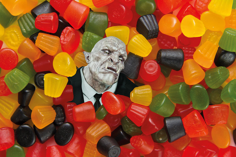 Trolls head surrounded by sweets to illustrate Universities must help scholars targeted by trolls