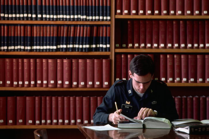 A West Point student reads a book in the library