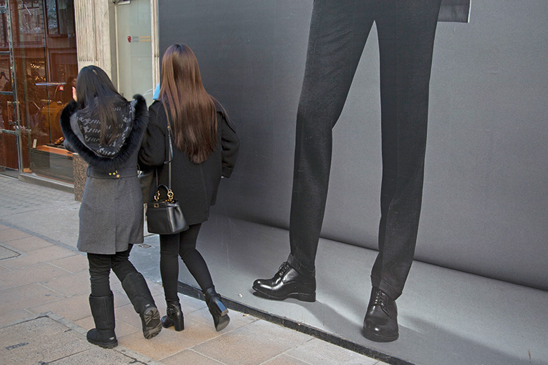 Women walking past mans legs