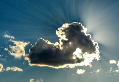 Sun shining behind black cloud