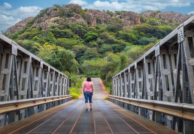 Woman walking across the metal bridge of Tobati, Paraguay