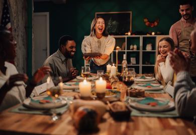 A group of friends laughing around the dinner table