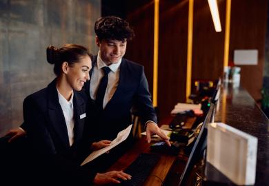 Two hotel workers at the hotel reception desk