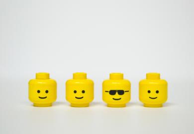 Four Lego heads, one wearing shades