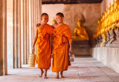 Two young Buddhist monks, walking through a monastery in Cambodia