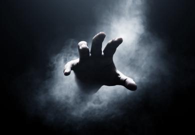 Hand emerging from darkness
