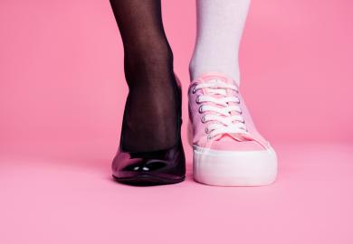 Person wearing one high-heeled shoe and one trainer