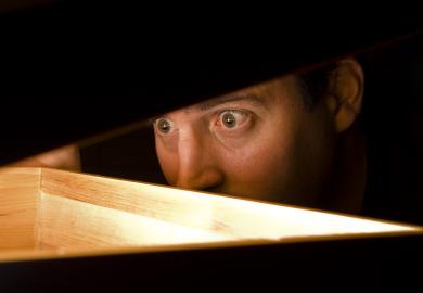Man looking into box with expression of shock