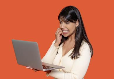 Woman looking at laptop with teeth clenched