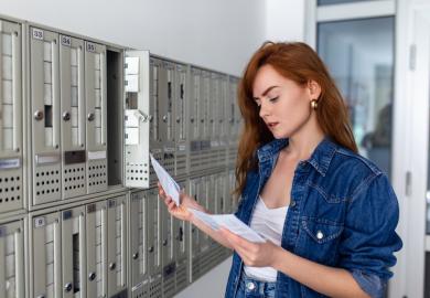 A young woman looks at a university admissions letter