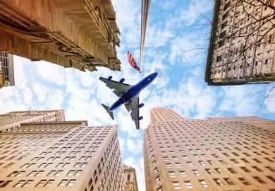 An aeroplane flies over American skyscrapers