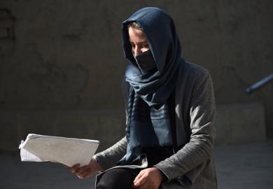 An unhappy Afghan scholar carrying a manuscript 