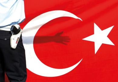 Armed guard standing in front of flag of Turkey