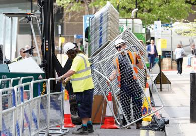 Construction workers erecting barriers