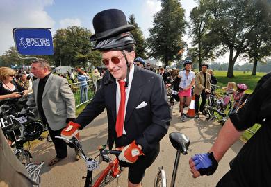 Man wearing suit and bowler hat on a bicycle