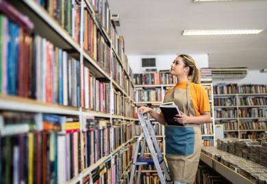 A student stacks bookshelves in a shop