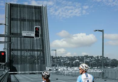 Two cyclists waiting at bridge 