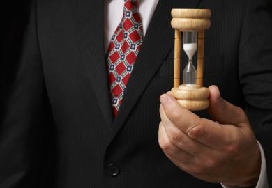 Businessman holding an egg timer