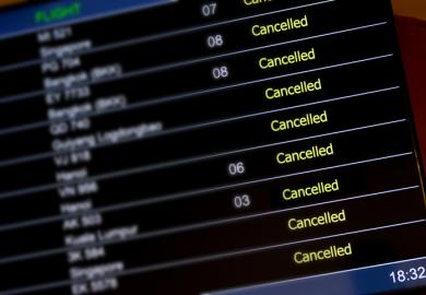An airport departure board with lots of flights cancelled illustrating an opinion article about cancel culture