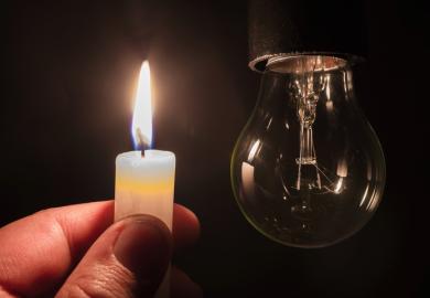 A lit candle and an unlit lightbulb