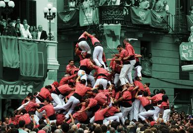 People fall as they attempt to form a “castell” during an exhibition of the human towers, or castells, in Vilafranca del Penedes, 2016