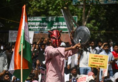 A supporter of the Cockroach Janta Party bangs a plate during a sit-in protest demanding the resignation of Indian education minister Dharmendra Pradhan in New Delhi in June