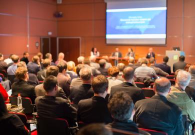 Conference audience illustrating return to in-person events via  hybrid mode