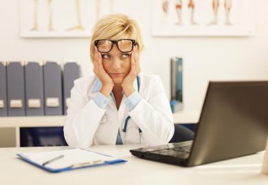 A doctor looking confused at her desk
