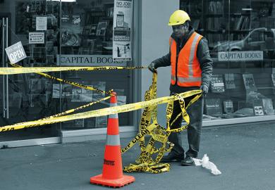 Worker putting up barrier tape
