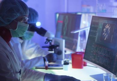 Scientists in protective suits look at Covid images online