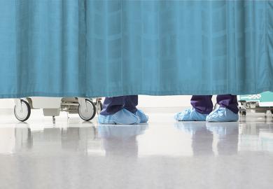 Feet of medical staff behind curtain