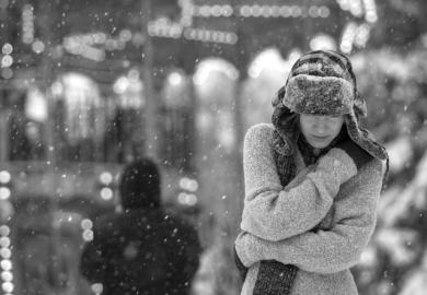 A depressed woman walks in the snow