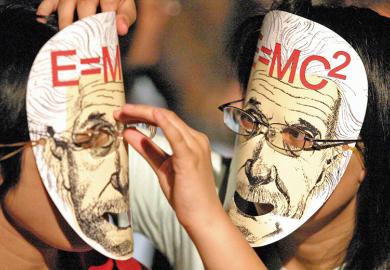 Two people wearing Einstein masks