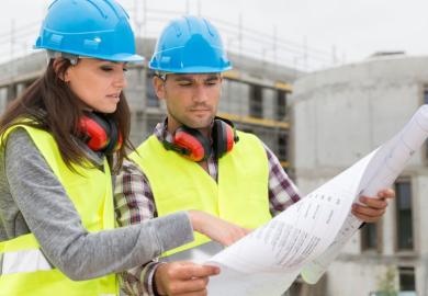 Engineers on building site checking plans