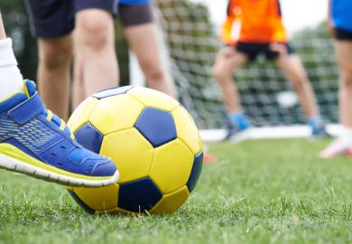 Football player kicking ball towards goal