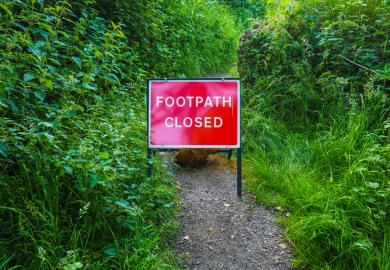 A footpath with a sign saying it is closed, illustrating restrictions on free speech