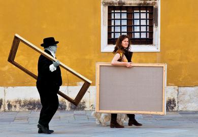 Two people carrying picture frames