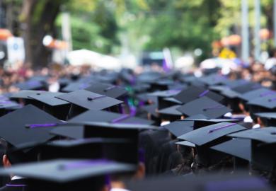 A line of graduates proceeding into a blur, illustrating uncertain prospects