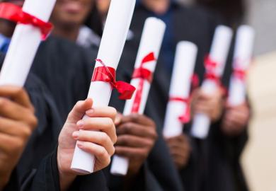 Group of graduates holding degree certificates