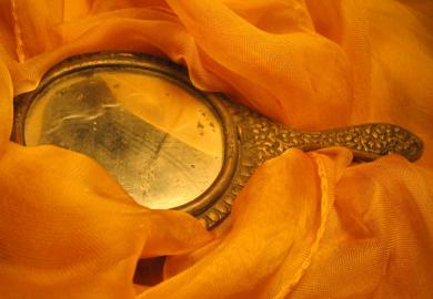 Handheld mirror laid on fabric