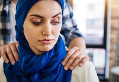 A Muslim woman with male hands on her shoulders, signifying sexual harassment in the Middle East