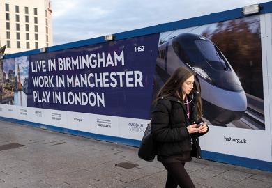 A woman walks in front of a billboard advertising HS2