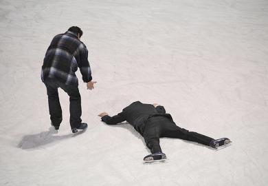 Man helps fellow skater who has fallen on the ice