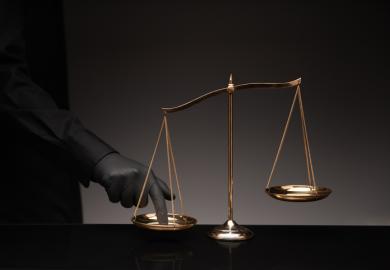A man presses his finger on the scales of justice