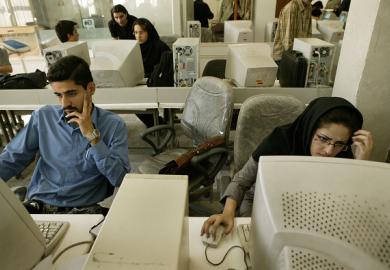 Iranian students on computers, illustrating online universities