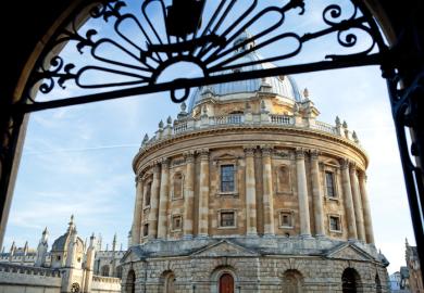 A view of the Radcliffe Camera through a gate at the University of Oxford in England