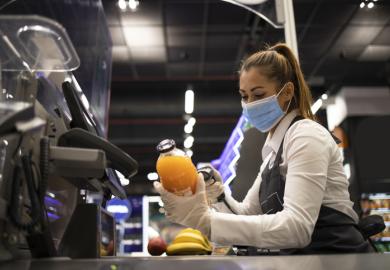 A checkout worker wearing a mask